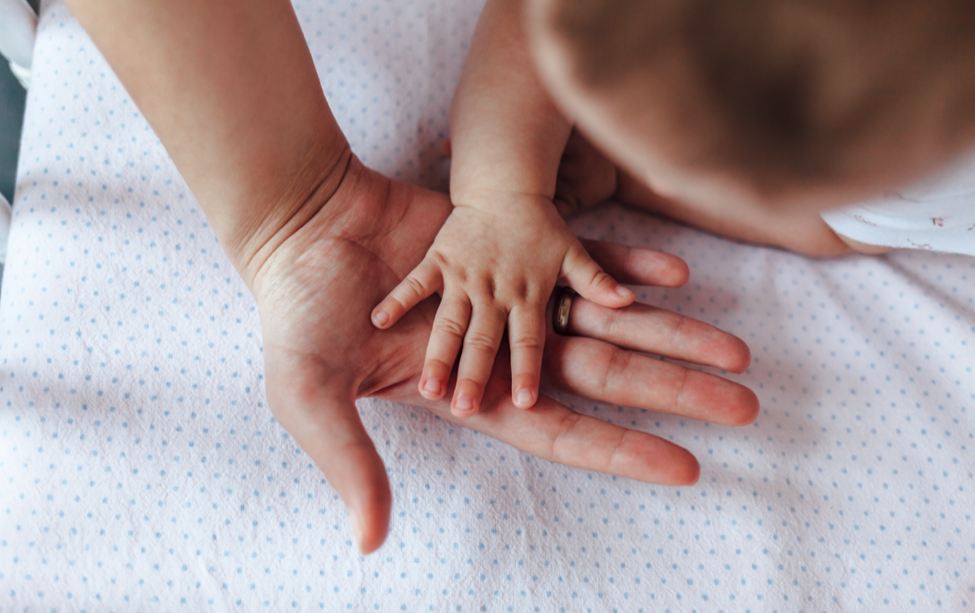 Las manos de una madre y su bebé