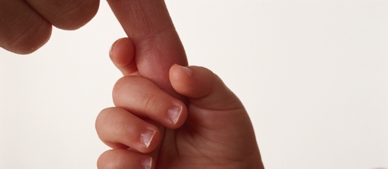 Baby hand holding an adult finger